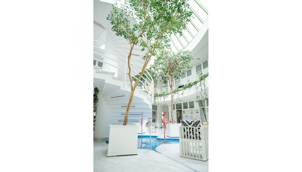 Los tilos del edificio y un oasis estilizado, que evoca el agua de manantial utilizada en los productos...