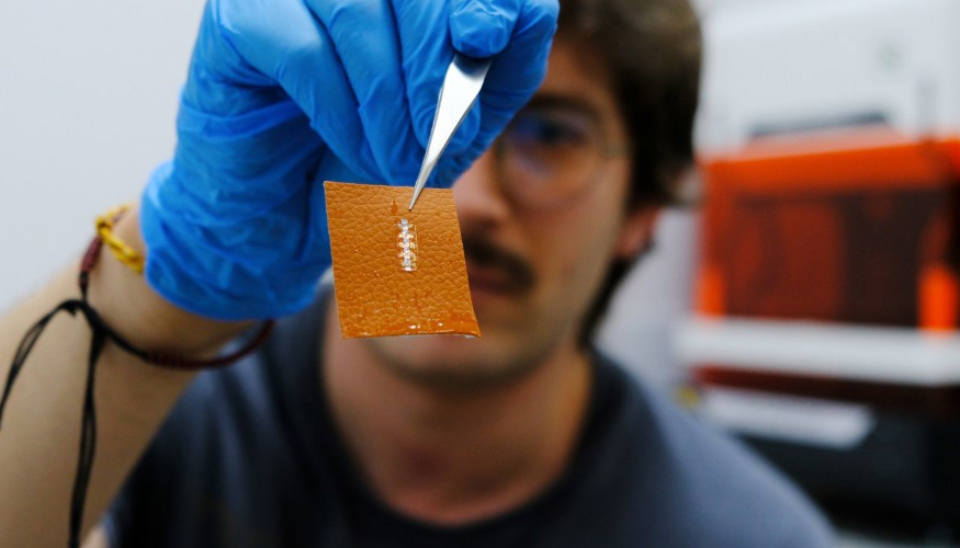El investigador Yigit Sozen sostiene un chip en un trozo de piel. Foto: �ngela R. Bonachera. ICMM-CSIC