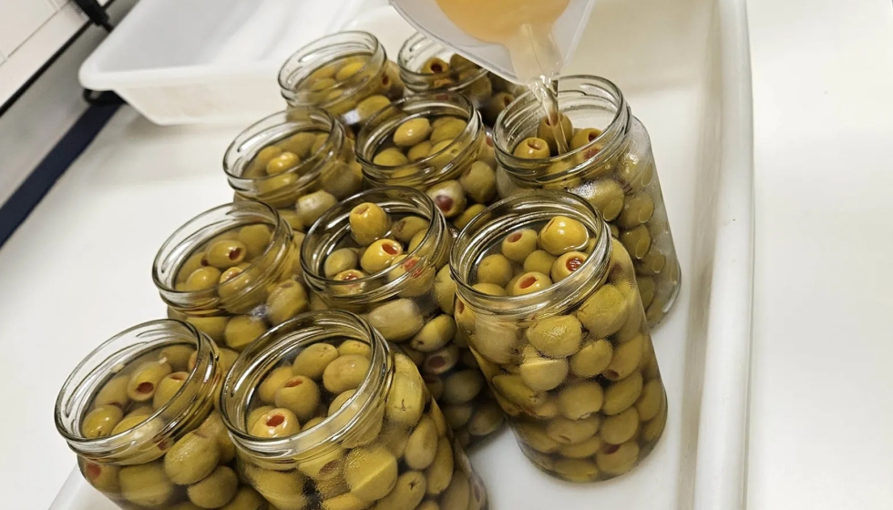 Llenado de frascos de aceitunas rellenas con salmueras de envasado