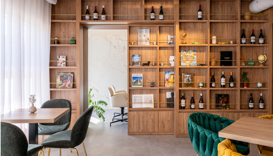 La librer�a dise�ada a medida separa el restaurante de la oficina inmobiliaria e integra un m�dulo corredero que conecta ambos espacios...