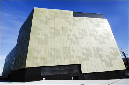 La piel exterior del edificio, de chapa perforada de color dorado, integra el logotipo de la universidad