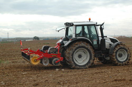 A Valtra N123 working with an apero stuck in the rear part of the tractor