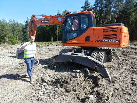 Cedric Prins, product manager for Europe of Doosan excavators, next to the new model's wheels DX140W