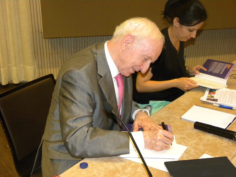 Leopoldo Abada firmando libros tras su ponencia en que expuso su particular forma de entender la crisis