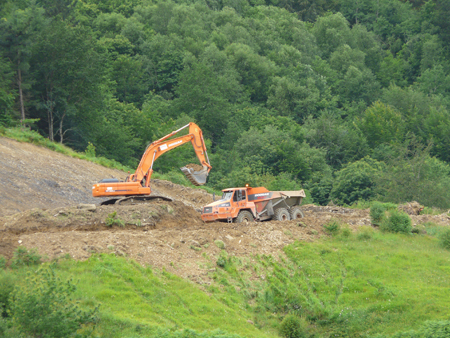 Excavator DX480 chains of Doosan, loading on an articulated dump truck MT 41 of the same brand