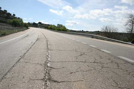 Carretera nacional: grietas en el pavimento y marcas viales desgastadas