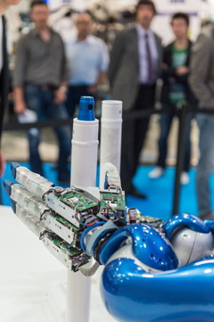 Un robot de la feria sujeta dos tubos alargados